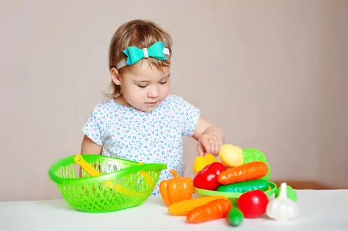 girl playing with plastic fruits